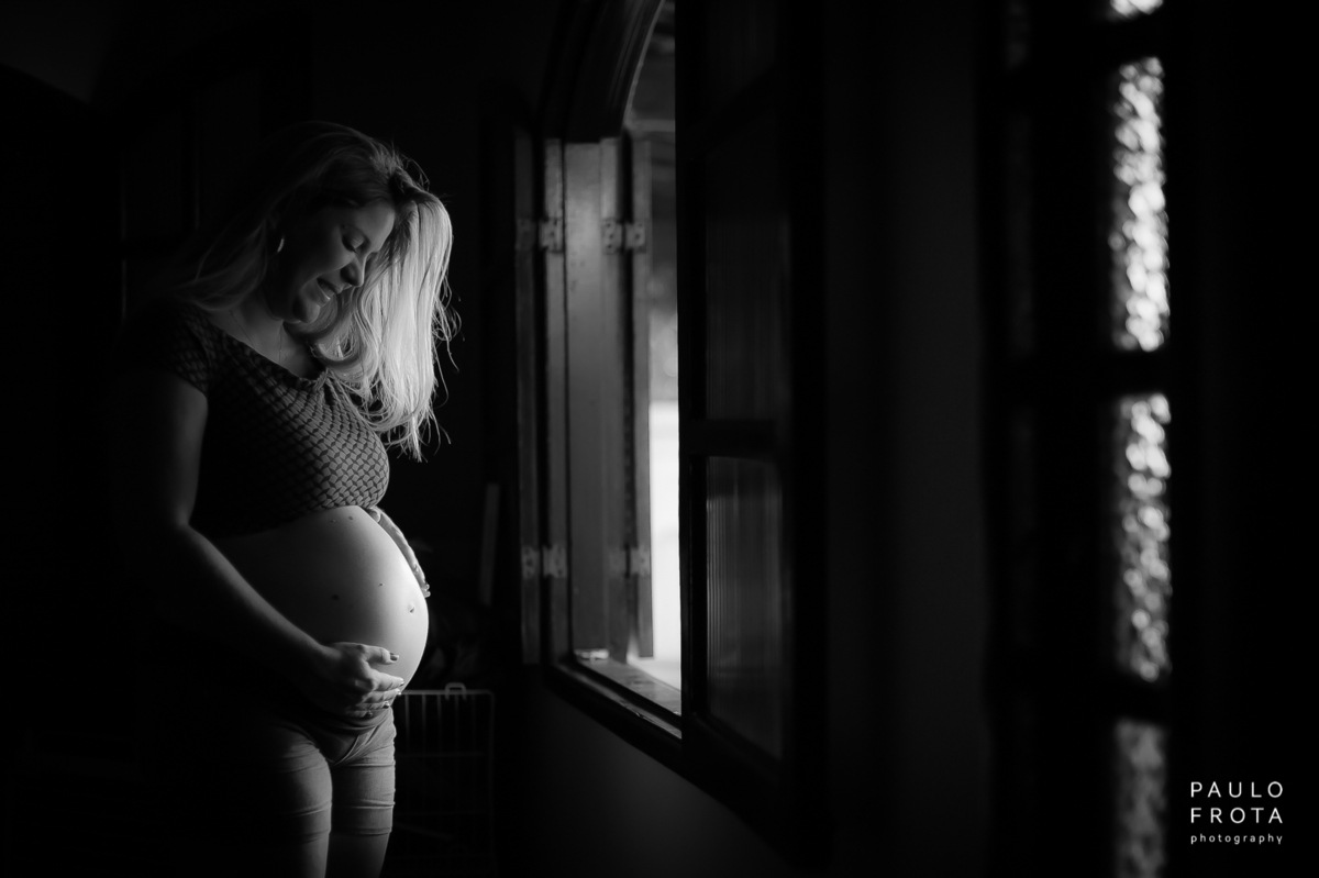 gestante olhando para o bebe ainda na barriga.