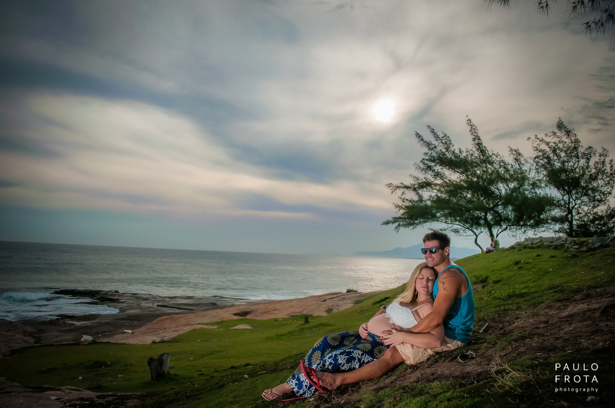 foto do casal deitado na grama da igreja, com horizonte ao fundo.