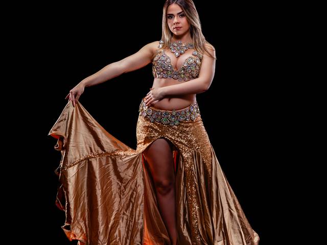 Família de Ensaio de dança do ventre com fundo preto e vestido dourado 