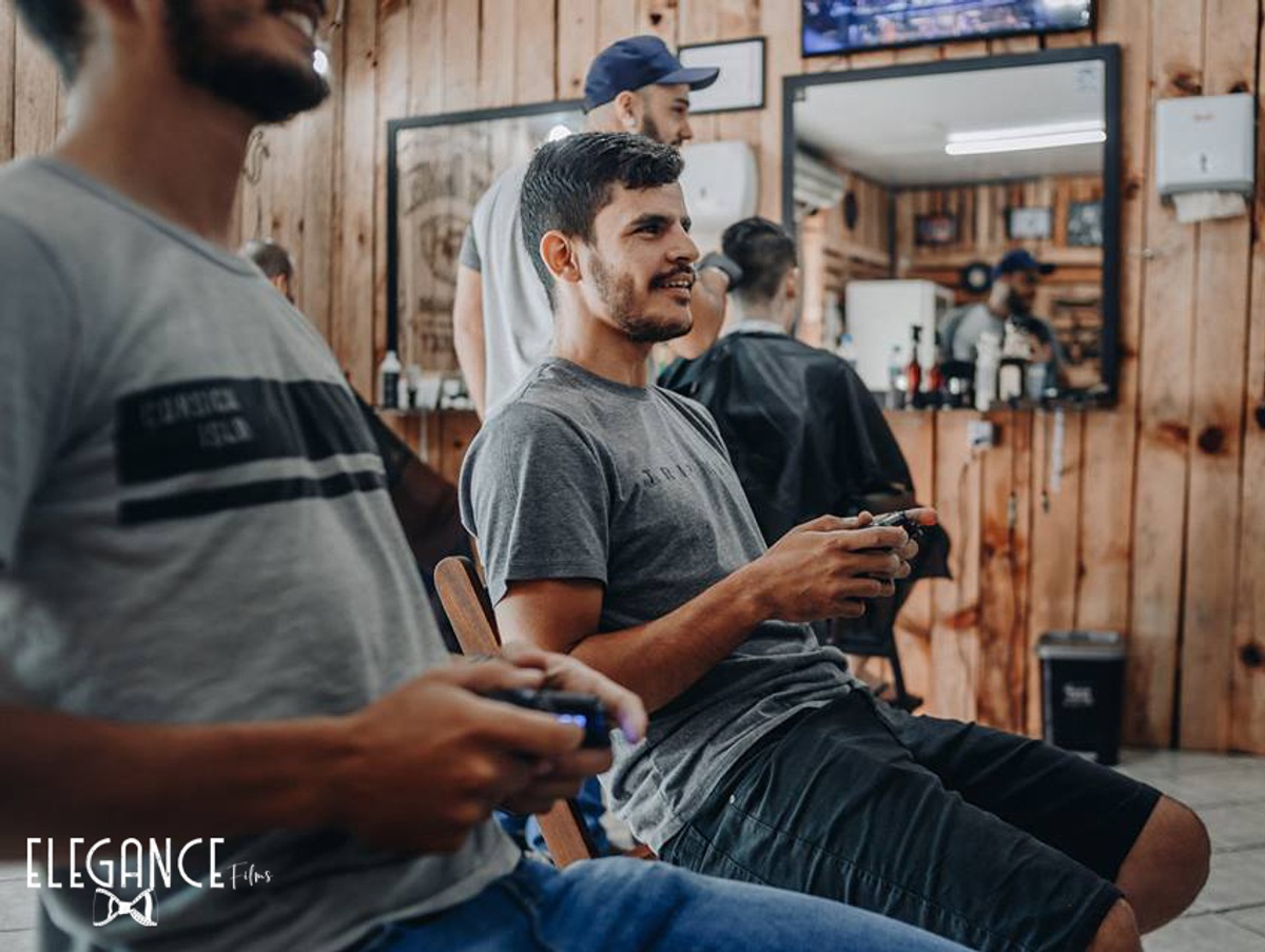 Noivo feliz jogando vídeo game durante o making of junto com os padrinhos
