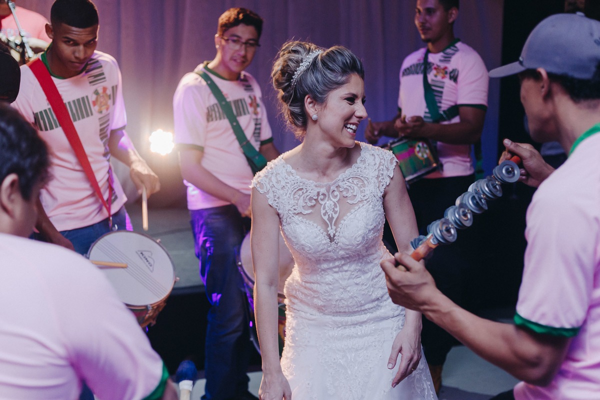 Noiva linda e feliz dançando junto com a bateria da escola de samba na festa de casamento