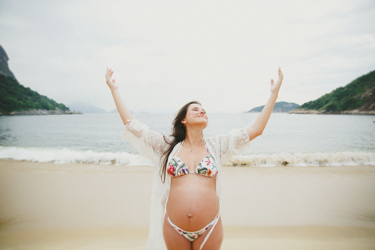 grávida agradecendo a Deus a chegada de sua primeira filha na praia