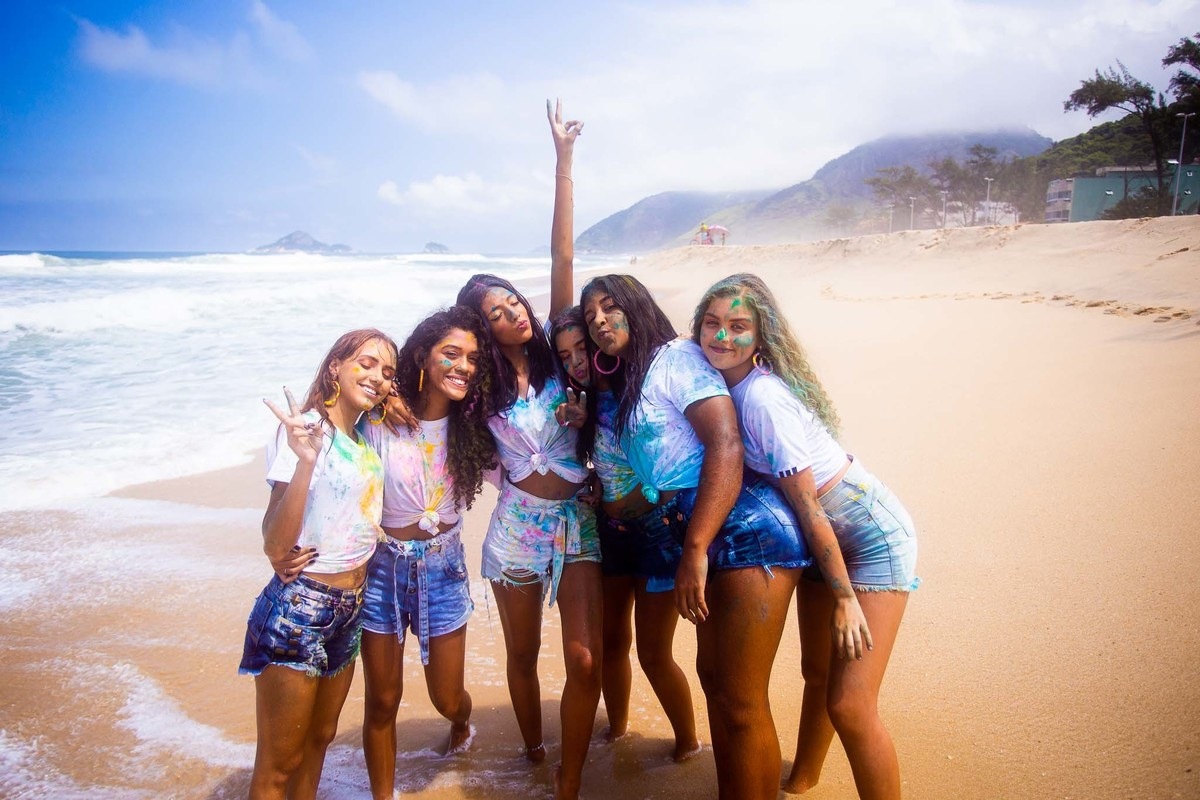 6 amigas posando pra foto na areia da praia da reserva no Rio de Janeiro.