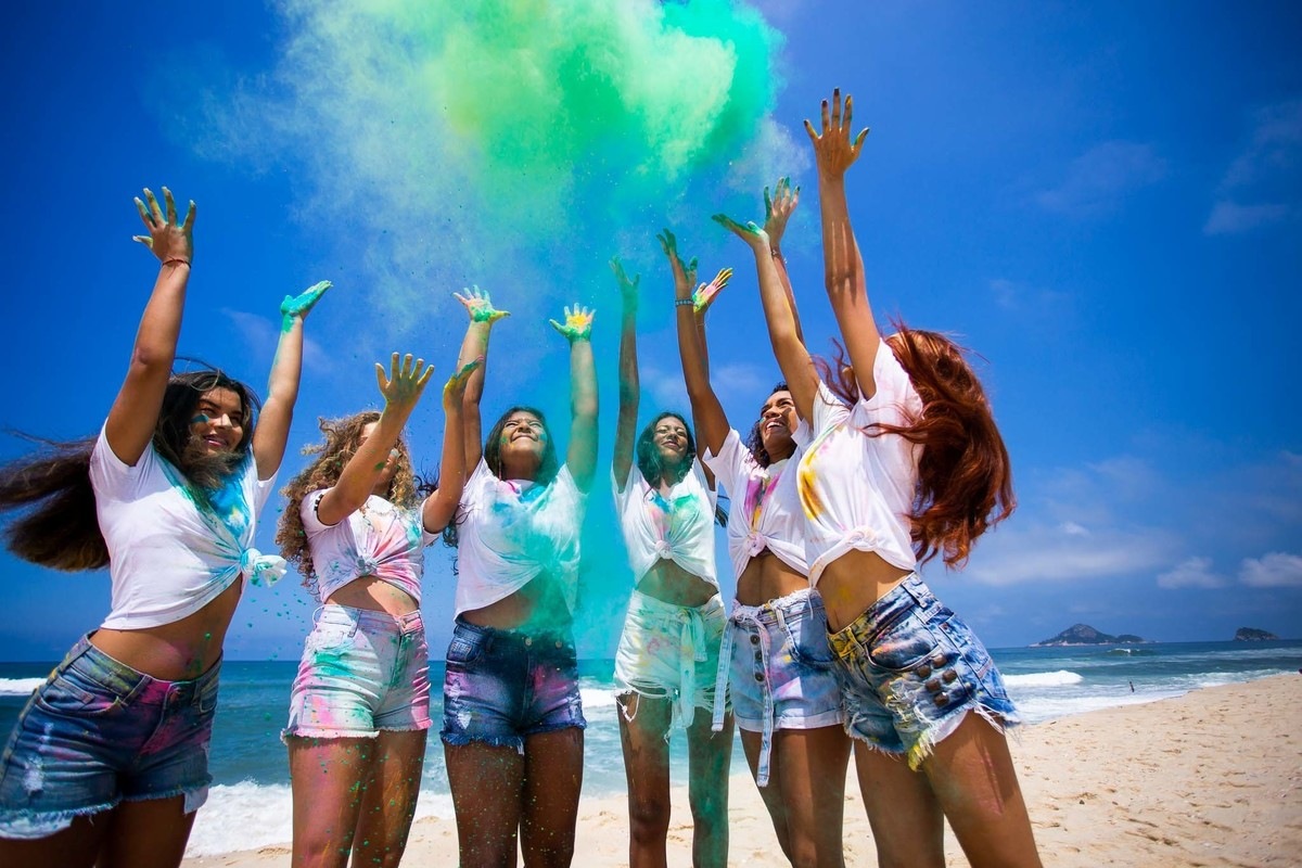 meninas jogando pó colorido pro céu.
