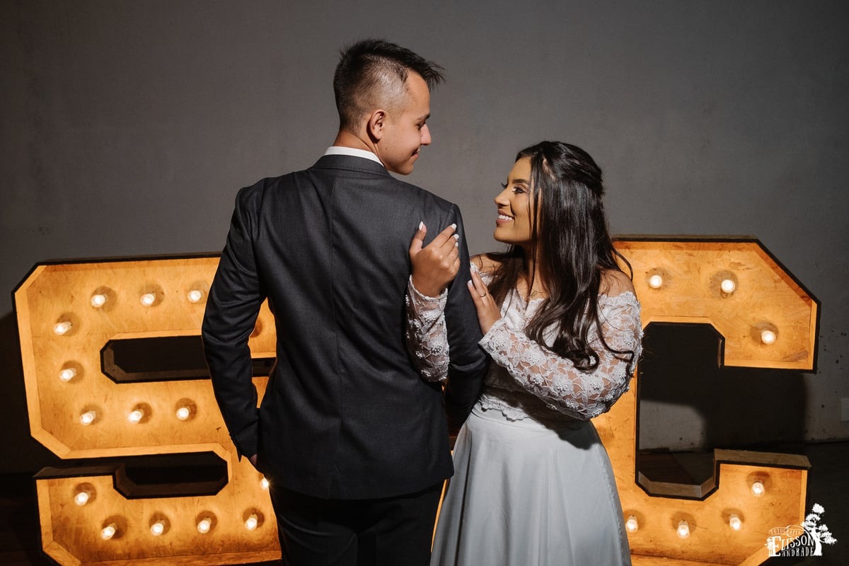 foto de casal com letreiro grande iluminado, casamento Boho