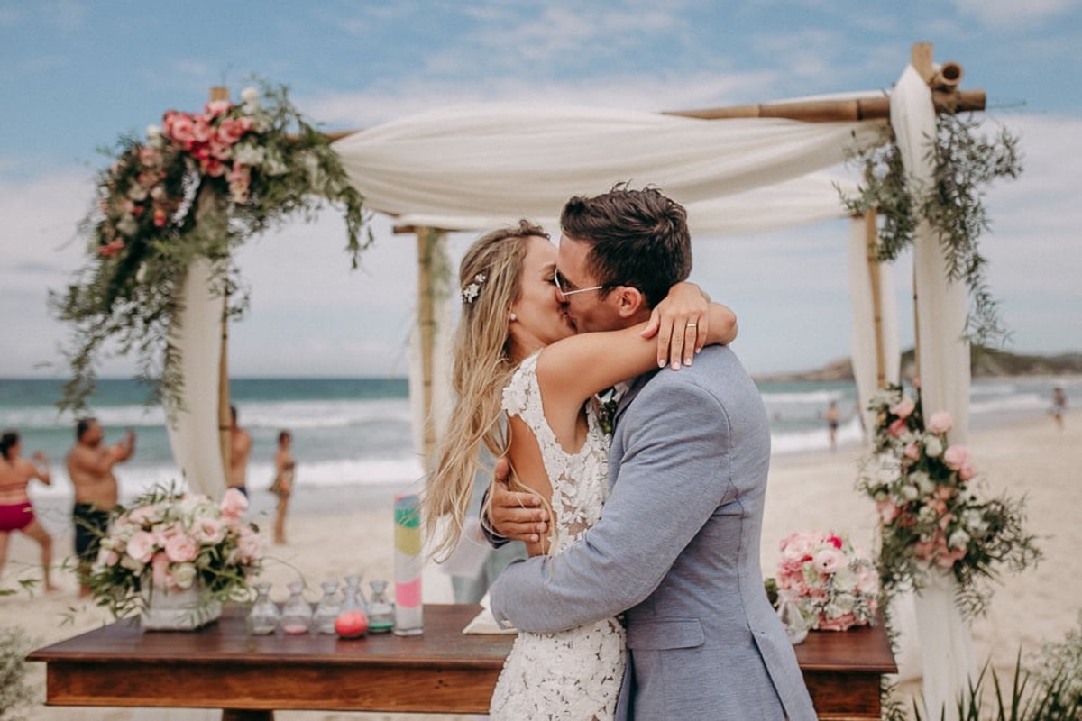 casal se beijando em casamento na praia