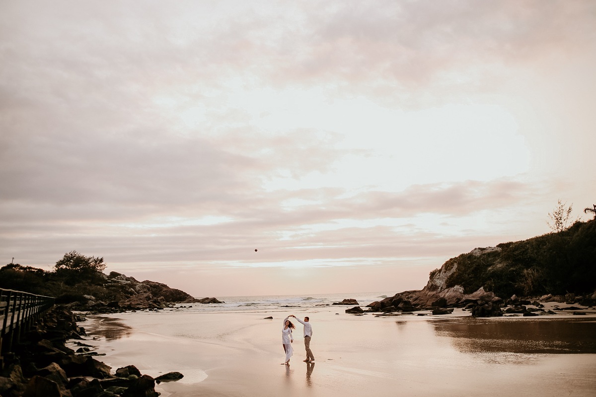casal na areia da praia nascer do sol