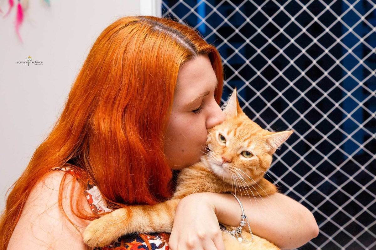 Tutora dando um beijo em seu gato, durante um ensaio pet em sua casa em Belo Horizonte.
