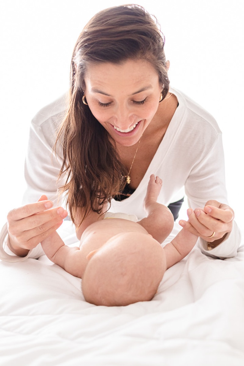 mãe brincando com bebê recém nascido