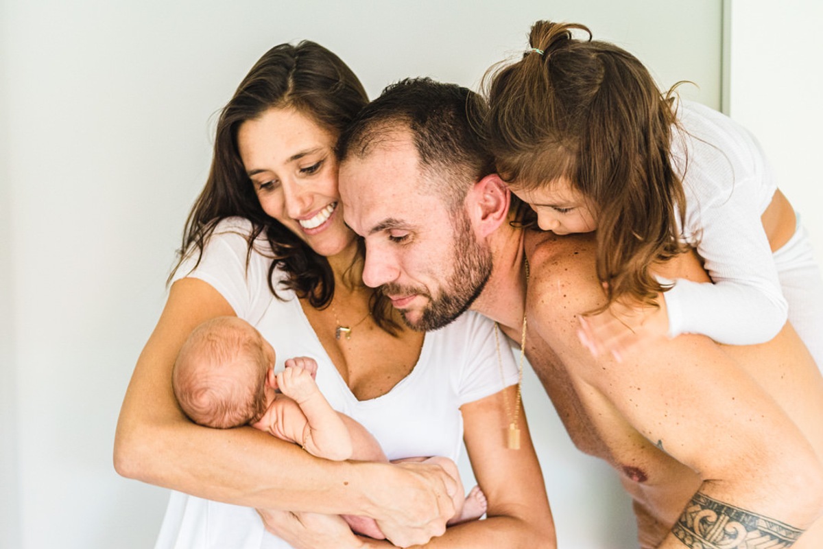 Família admirando bebê recém nascido - mãe, pai, filha pequena admirando bebê recém nascido