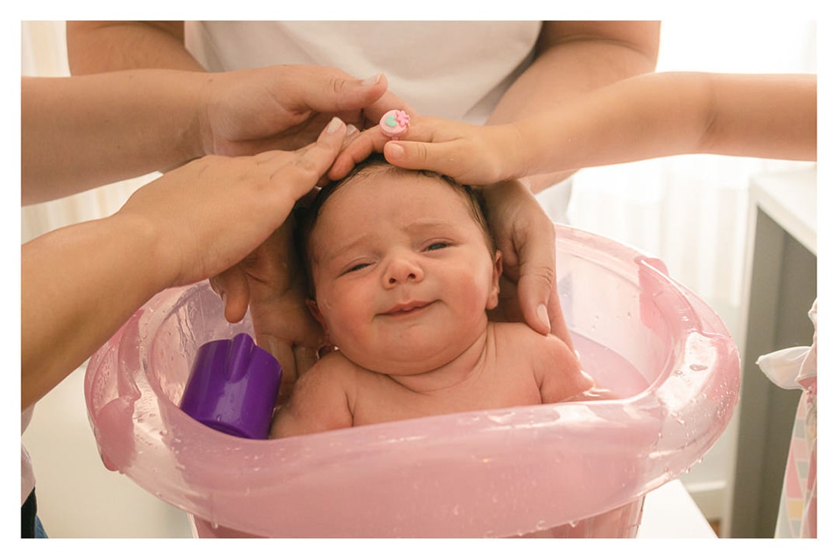 família, pai, mãe e irmã dando banho no ofurô em bebê recém nascido, durante a sessão de fotos de newborn lifestyle em Curitiba, do fotógrafo infantil e de família Rapha Luna