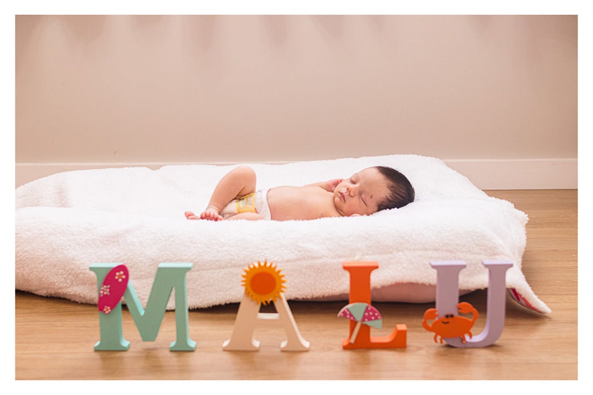 bebê recém nascido deitado com objetos de decoração do quarto, durante a sessão de fotos de newborn lifestyle em Curitiba, do fotógrafo infantil e de família Rapha Luna