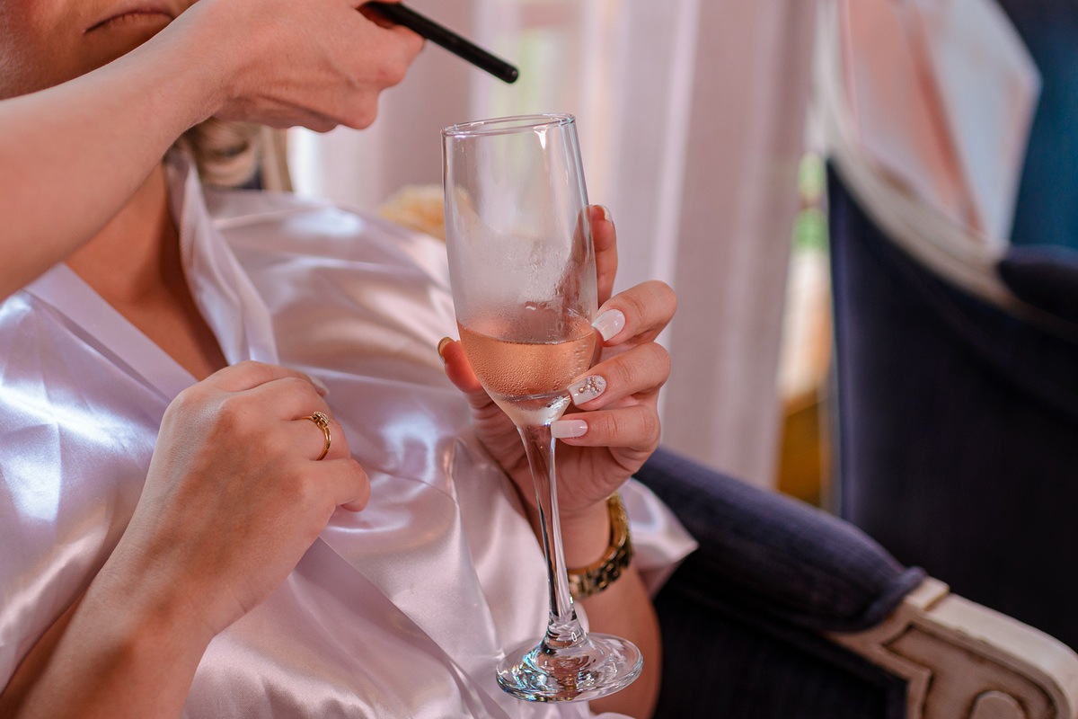 detalhes das unhas e da taça na mão da noiva
