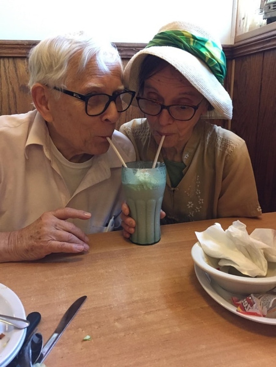 Casal de idosos tomando milk sheik no mesmo copo