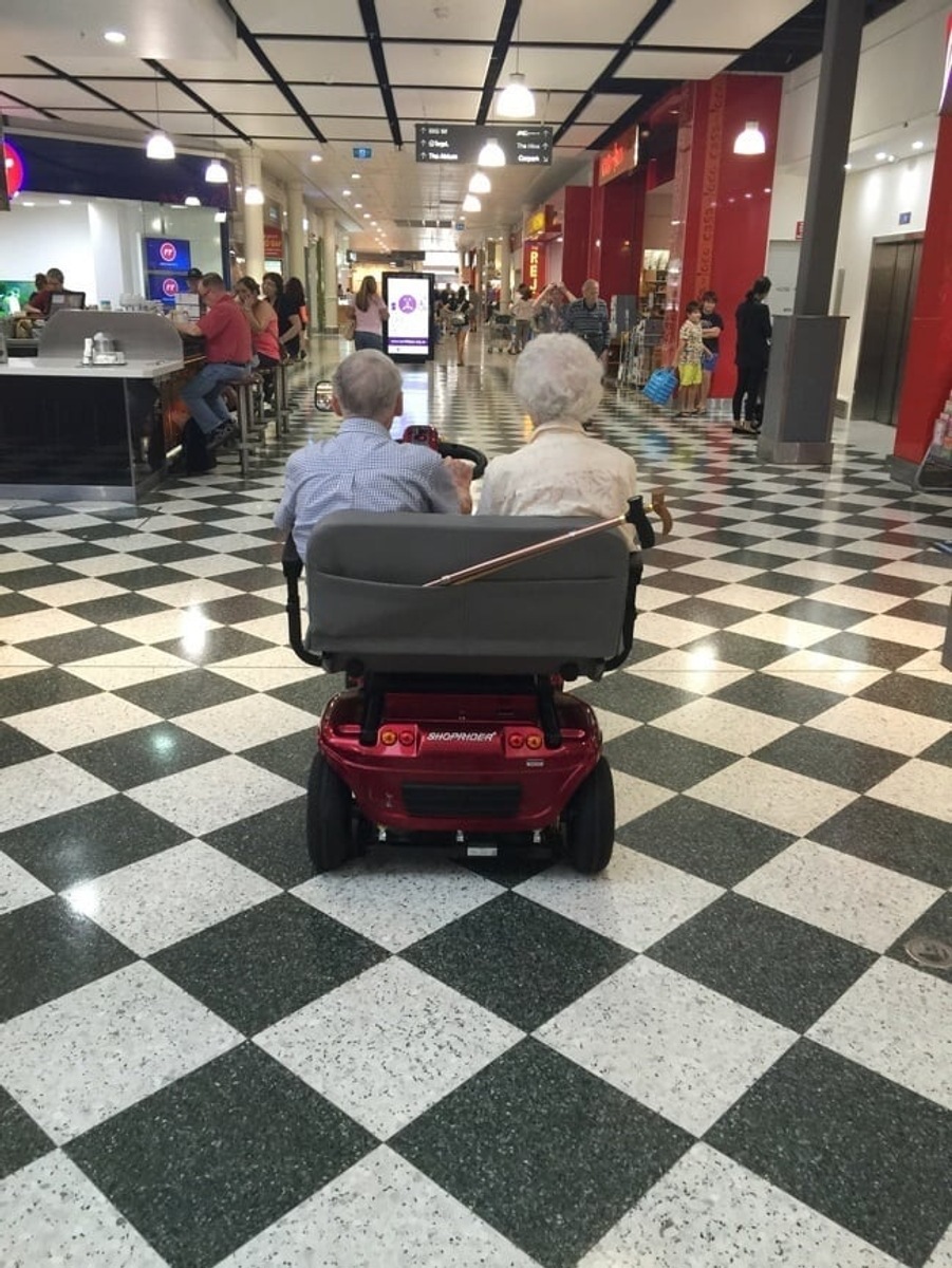 Casal de idosos em uma scooter para dois