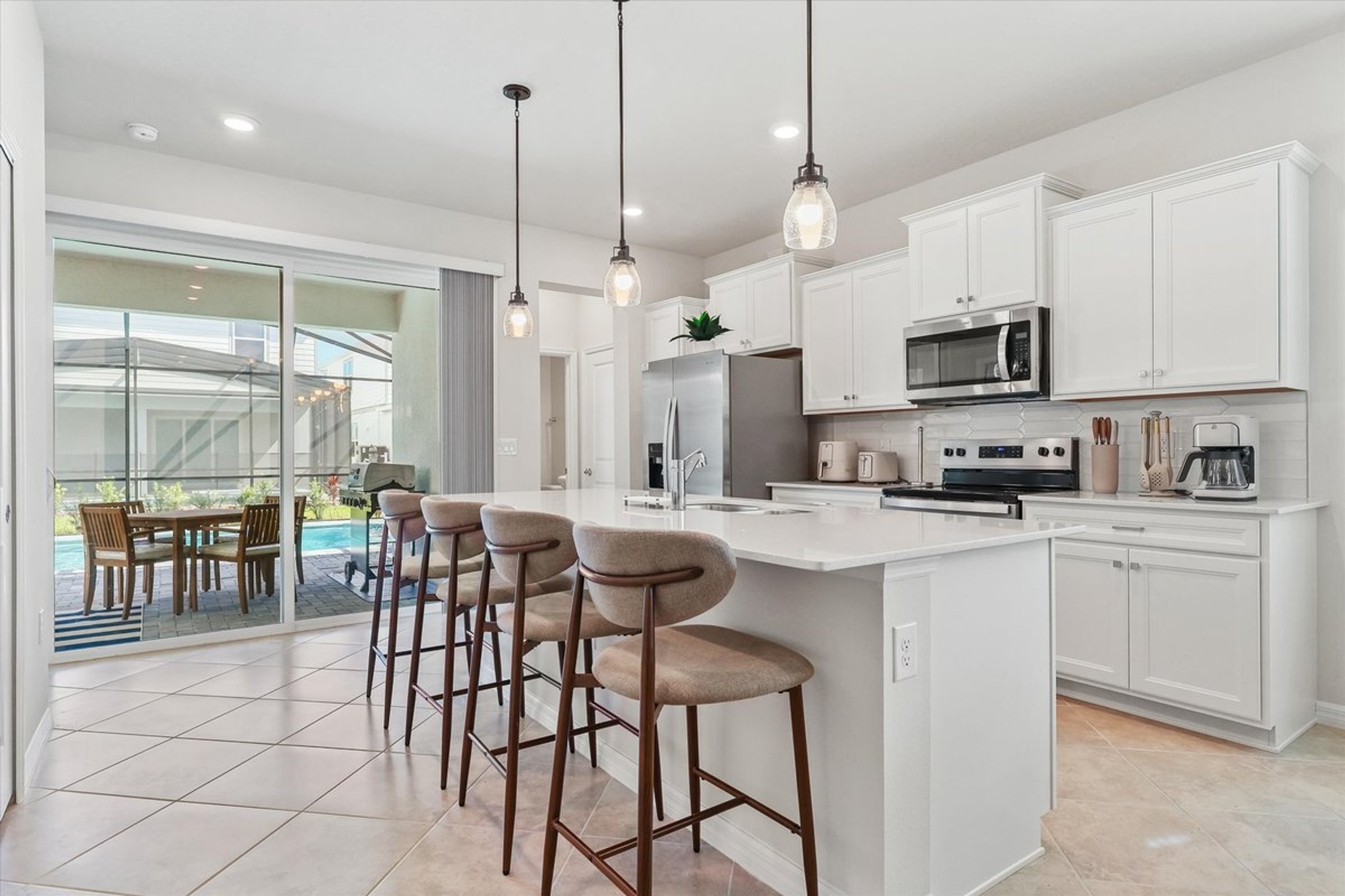 Windsor Cay kitchen with a white island and an open connection to the covered patio.