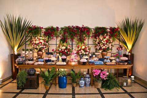 Mesa de doces com o bolo no centro.'