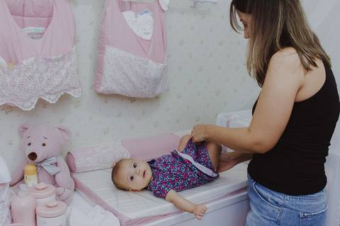 mãe trocando bebê em ensaio de família em casa em ribeirão preto '