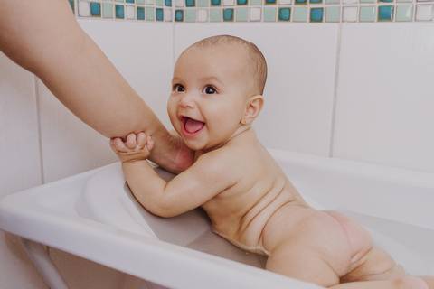 bebê tomando banho em ensaio de família em casa em ribeirão preto'