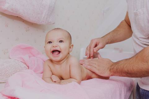 pai trocando a fralda de bebê em ensaio de família em casa em ribeirão preto'