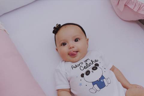 bebê mostrando a língua em ensaio de família em casa em ribeirão preto'