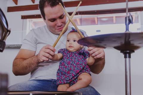 bebê tocando bateria em ensaio de família em casa em ribeirão preto'