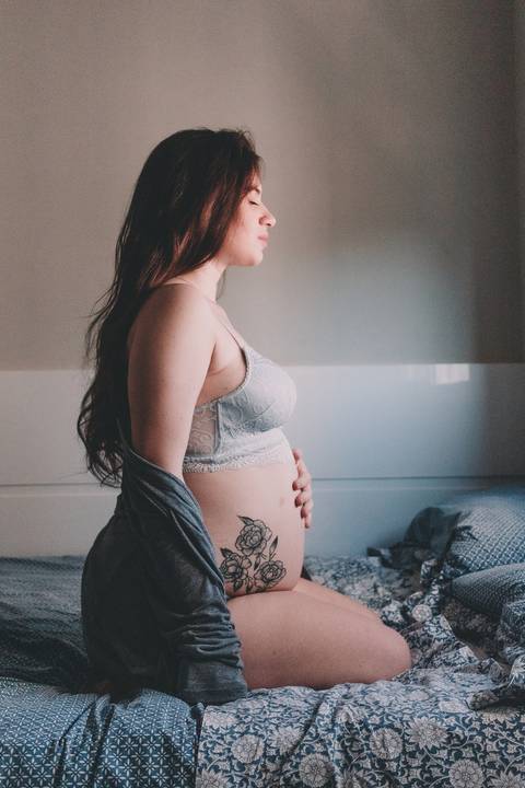 ensaio gestante com tatuagem em casa no quarto'
