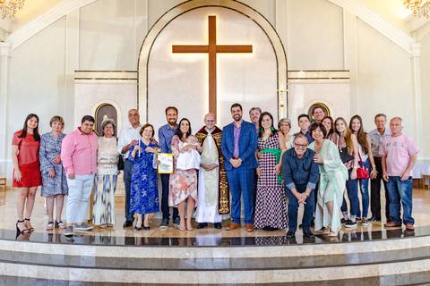 família reunida com padre em batizado na paróquia santa ângela em ribeirão preto'