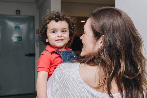 criança de cabelo enrolado sorrindo'