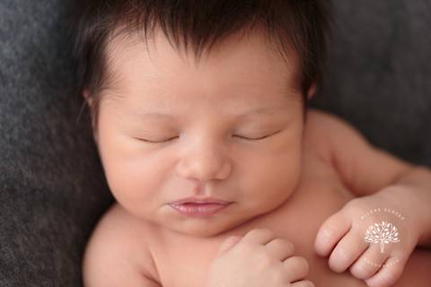 rosto de recém nascido cabeludo dormindo'