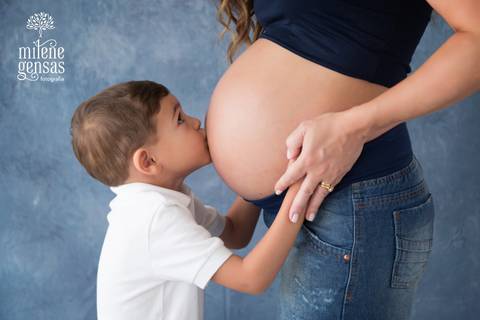 menino beijando a barriga de gestante da mãe'