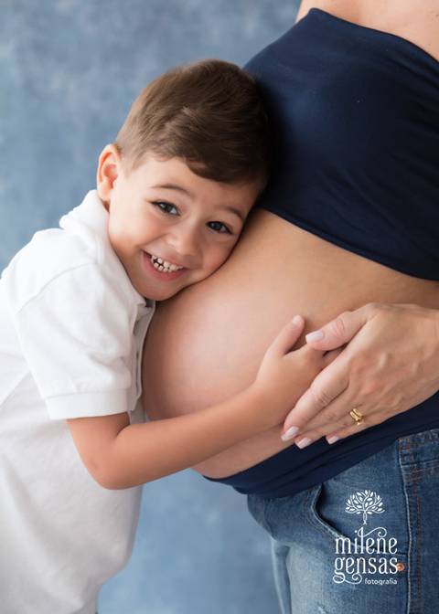 menino abraçando a barriga de gestante da mãe'