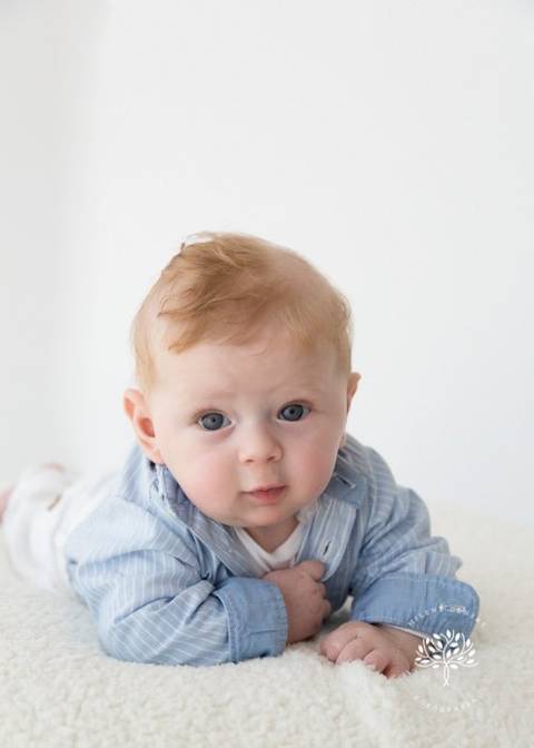 bebê ruivo 4 meses menino fundo claro de bruços camisa'