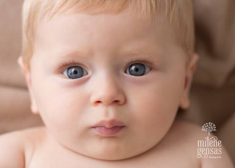 rosto de bebê ruivo com olho azul 7 meses menino fundo bege'