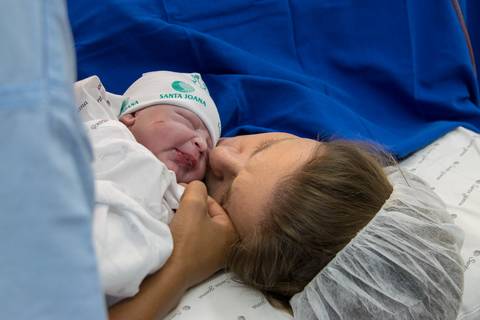 Fotografia de parto - Chegou o grande dia. O primeiro beijo entre mãe e filho...muita emoção. Emoção de ser mãe. Nascimento de um filho. Primeiros minutos da vida do bebe.'