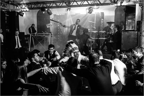 amigos se divertindo em festa enquanto o formando se prepara para tocar fumaça'