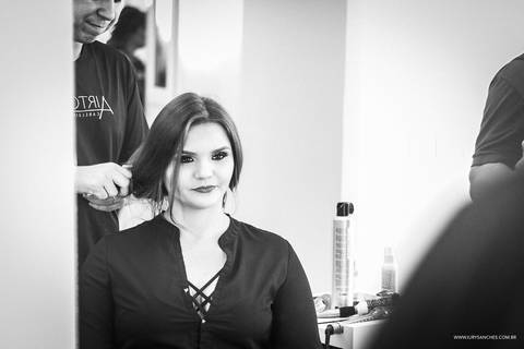 Menina se olhando no espelho durante seu making off no airton cabeileireiros'