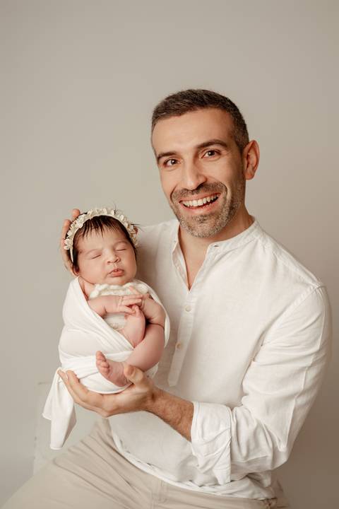 Fotografia de recém-nascido com o pai em estúdio em Lisboa. Momentos simples e emocionais em família.'