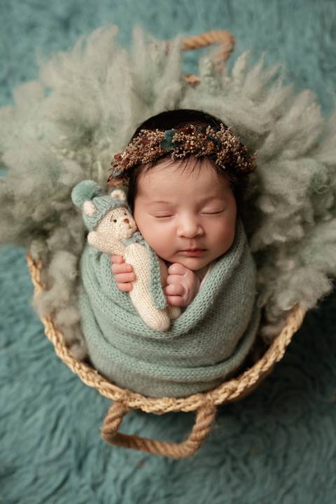Sessão recém-nascido em Lisboa com tons naturais e delicados. Fotografia de bebé em estúdio com styling orgânico.'