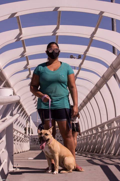 Jovem com máscara e com cachorro '