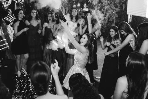 Fotografia da pista de dança da festa de 15 anos da Júlia com convidados, fumaça e muita animação.'