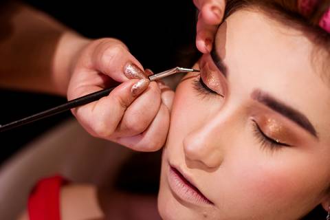Maquiagem da debutante Júlia nos preparativos para sua festa de 15 anos, registrada por May e José Fotografia.'
