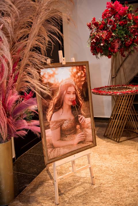 Retrato da debutante Júlia em meio à decoração da sua festa de 15 anos.'