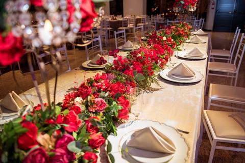 Decoração das mesas da festa de 15 anos da Júlia, com arranjos florais em tons intensos e elegantes.'