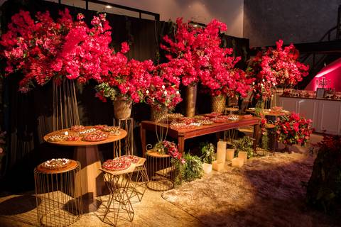 Decoração floral da festa de debutante Júlia, com composição marcante em tons de vermelho.'