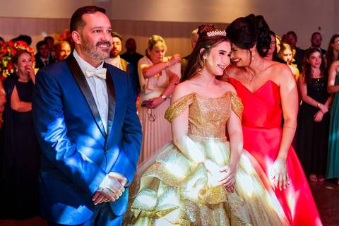 Júlia com seus pais durante um dos momentos especiais da cerimônia de 15 anos.'