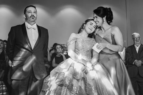 Abraço emocionante durante a festa de 15 anos da Júlia, registrado de forma espontânea por May e José Fotografia.'
