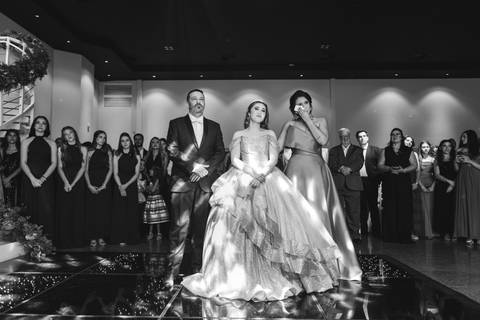 Pais da debutante Júlia emocionados durante as homenagens da cerimônia de 15 anos.'