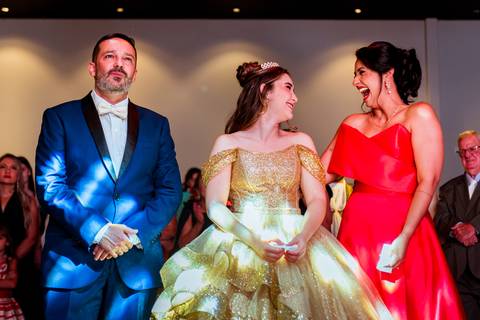 Momento de carinho entre Júlia e seus pais durante a celebração dos seus 15 anos.'