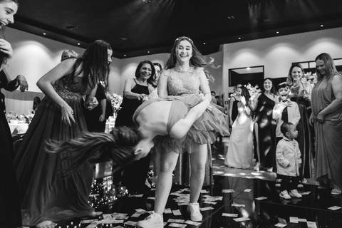 Fotografia da pista de dança da festa de 15 anos da Júlia com convidados, fumaça e muita animação.'